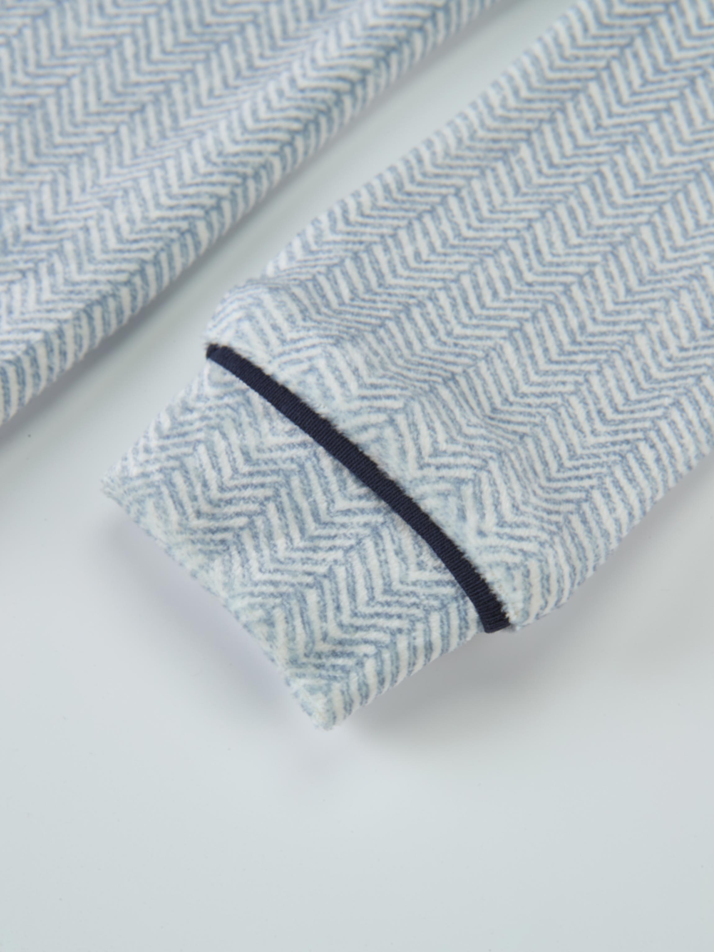 Boys pajamas in blue herringbone fabric with navy piping.