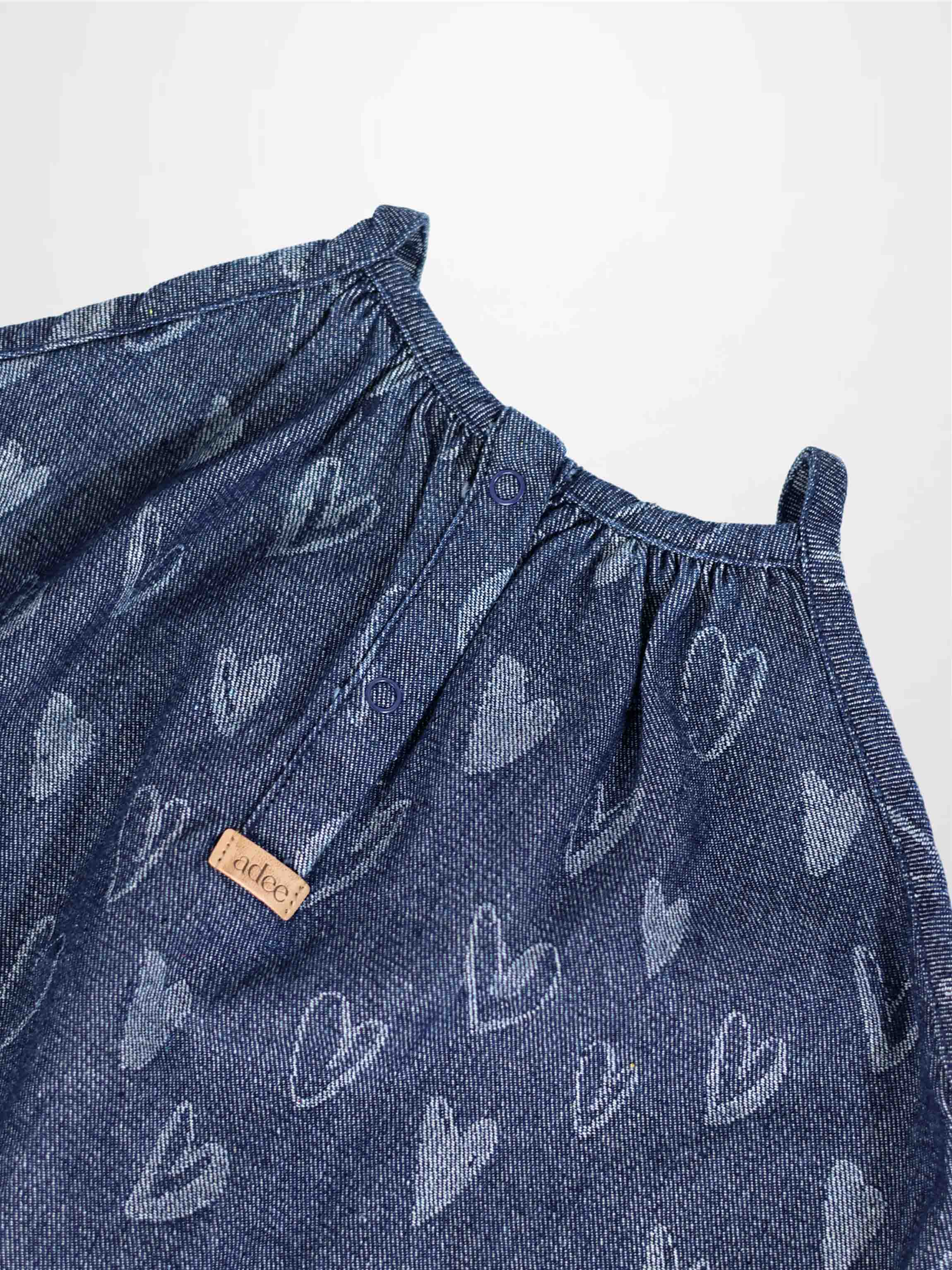 Denim heart jumper with light-gray heart prints, gathered neckline, and snap buttons.