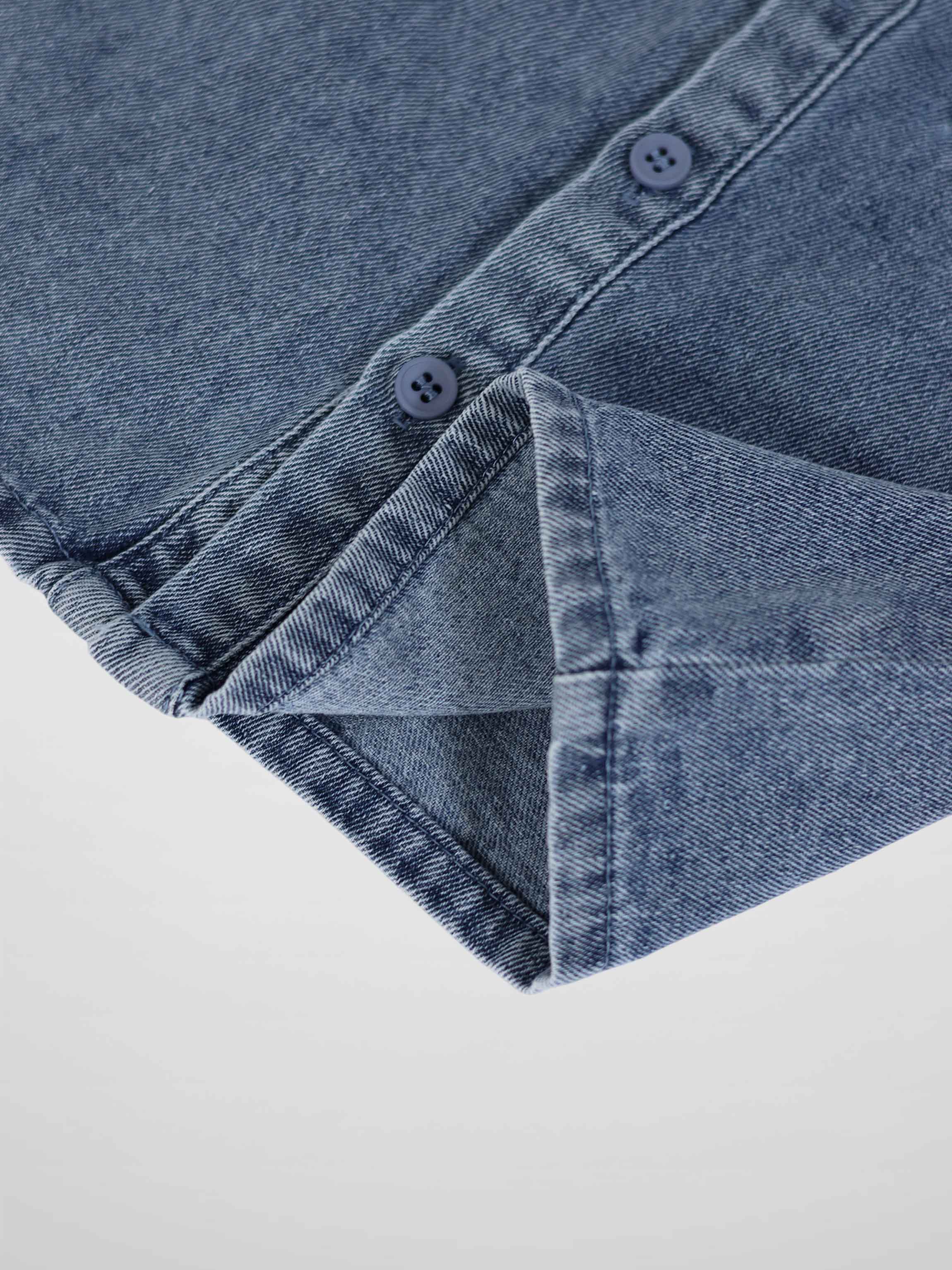 Blue denim romper with button-down front and cuffed sleeve, close-up
