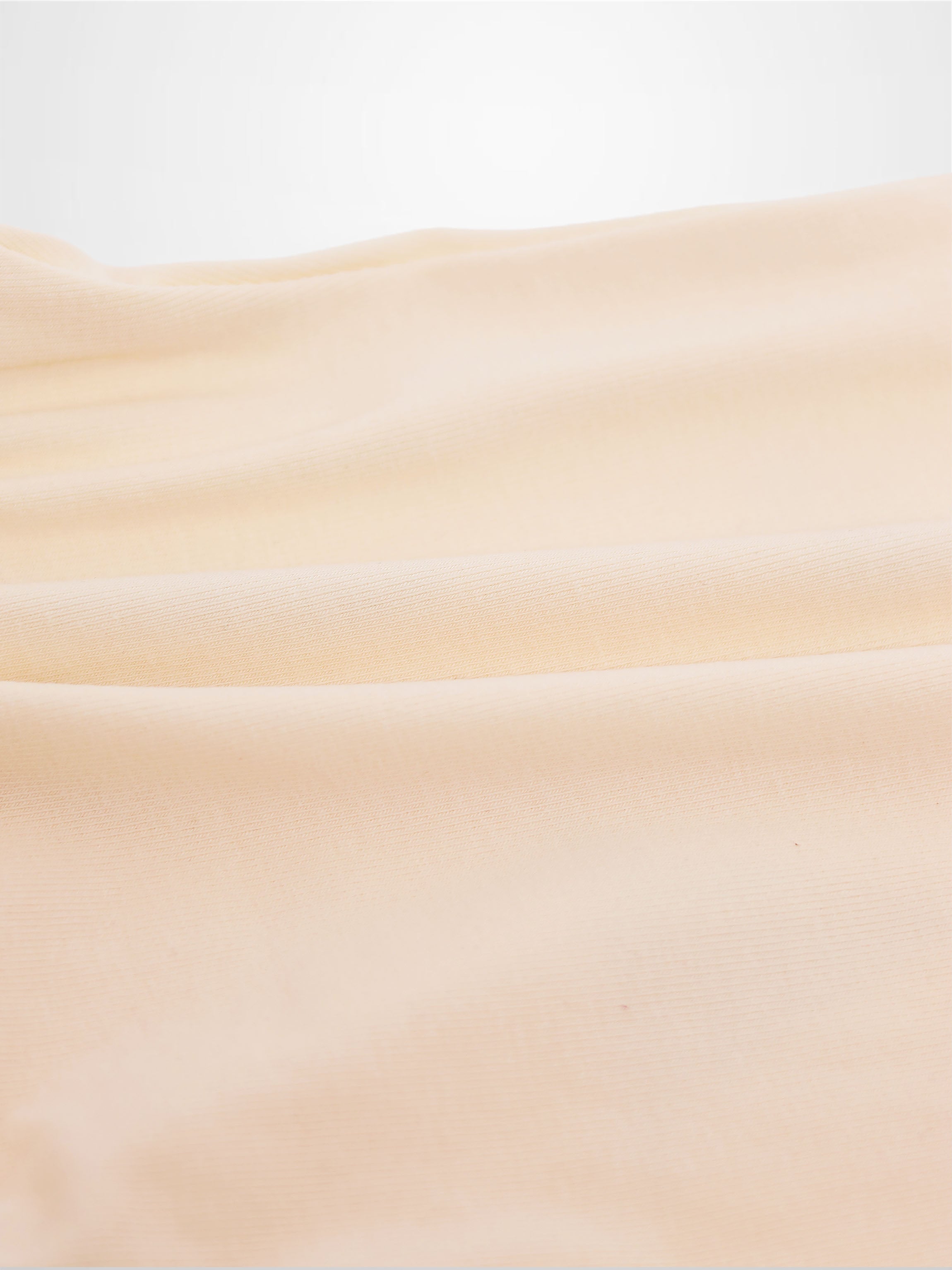 Soft peach fabric close-up for Sail Boat Romper, subtle knit texture.