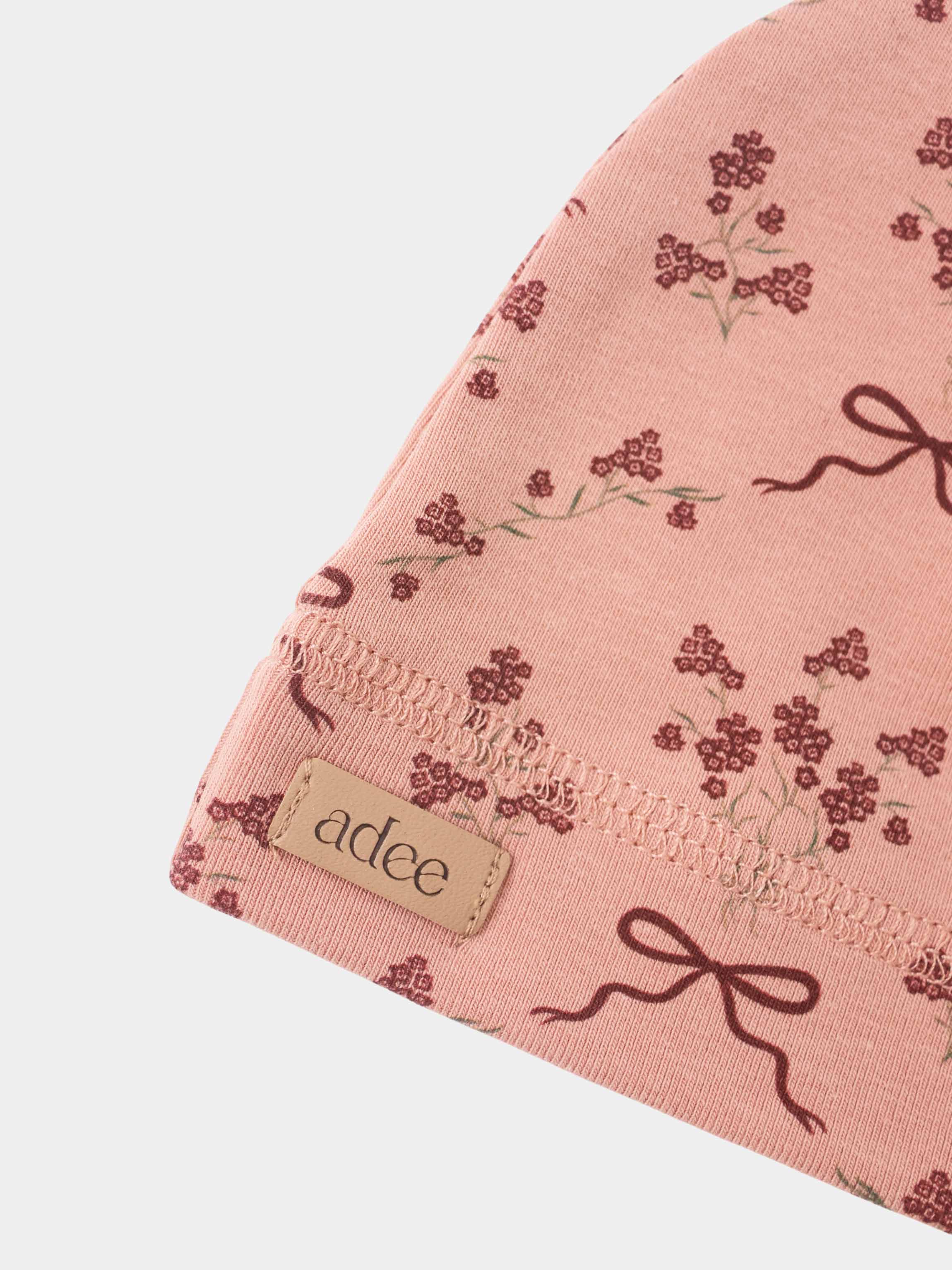 Adee Bow Bouquet Layette Set for girls; pink fabric with burgundy floral print and bow motif.