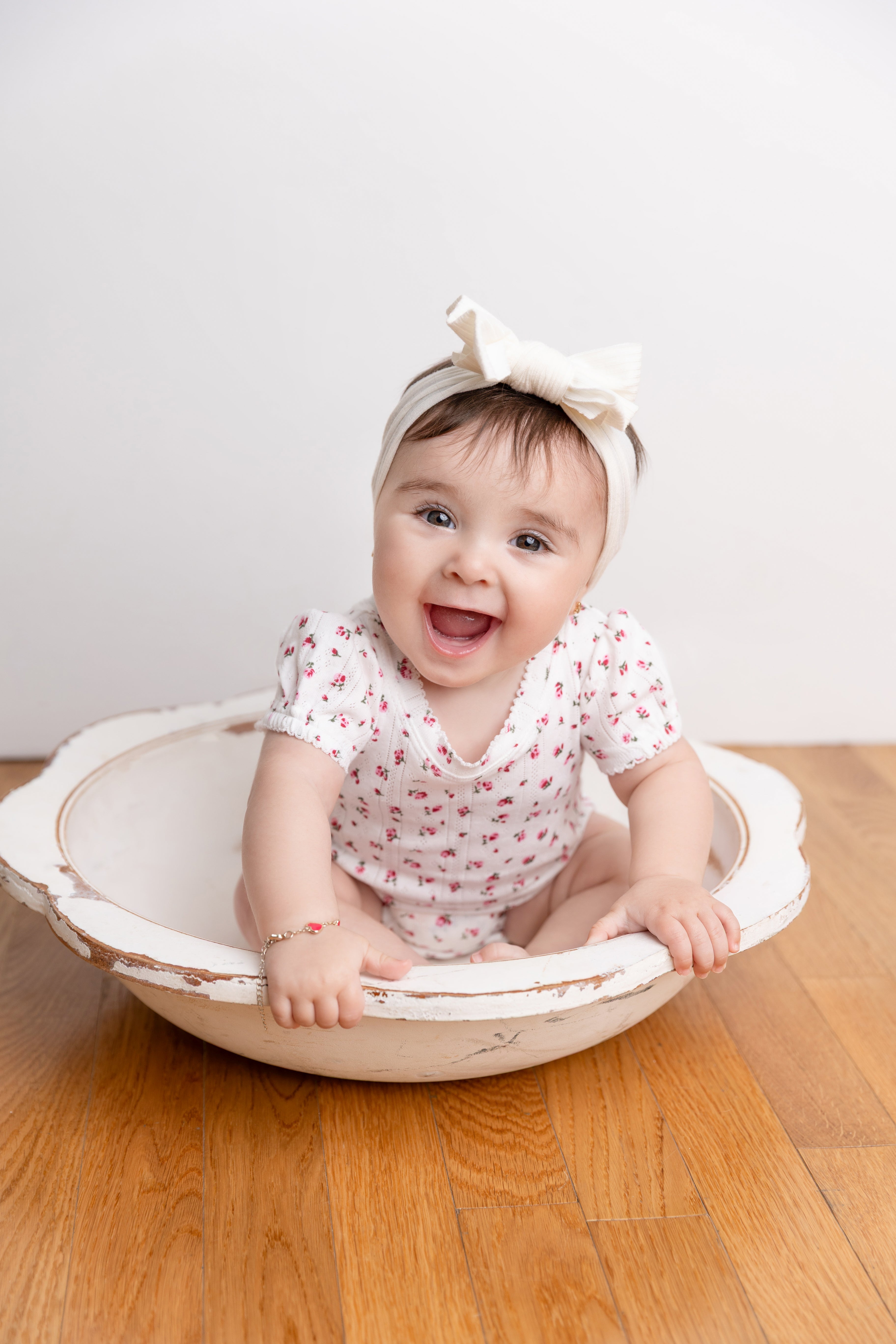 Pointelle Floral Romper for girls, white with pink flowers, worn by smiling baby.