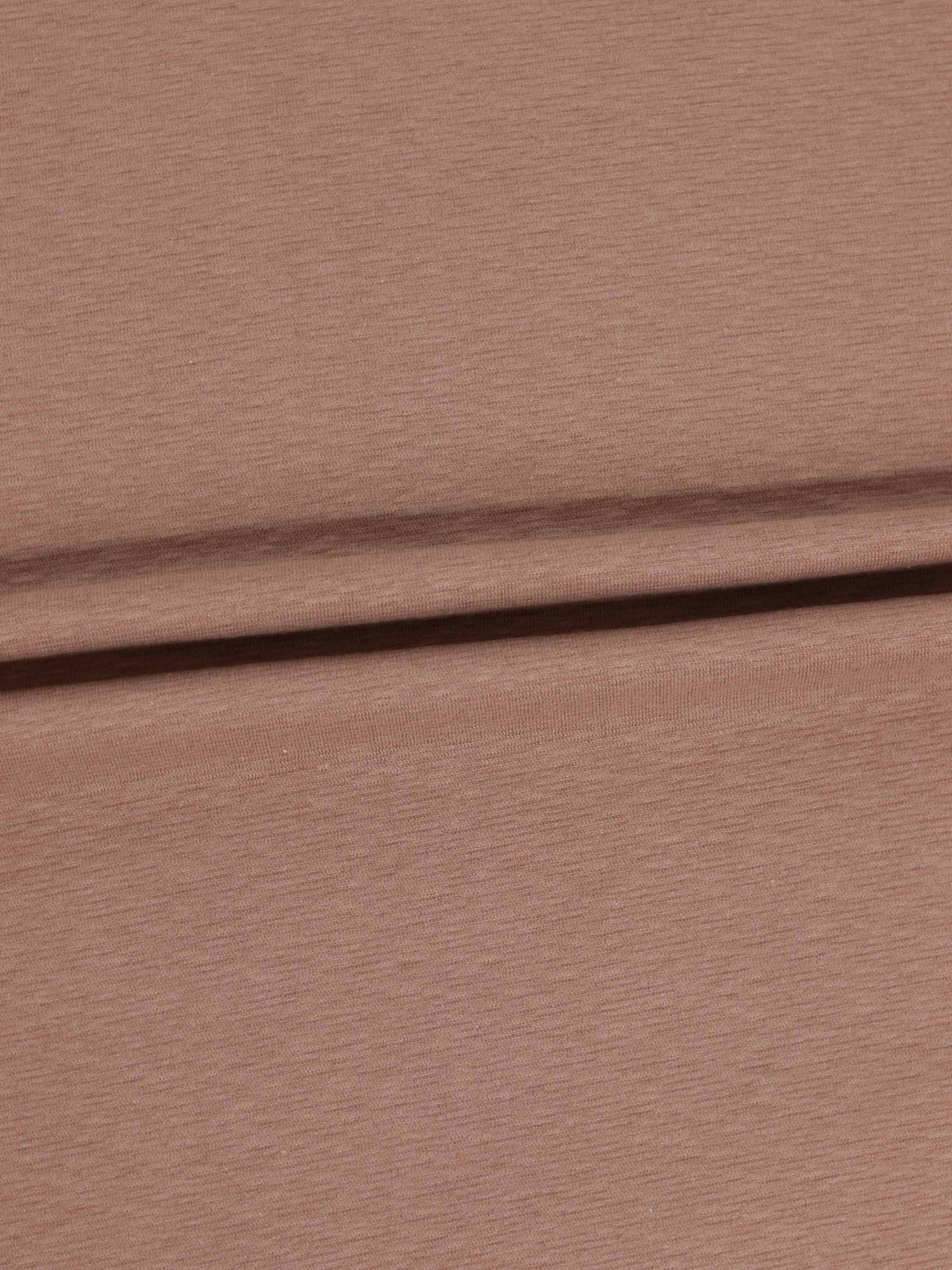 Dusty pink textured stretchy fabric close-up with a fold.