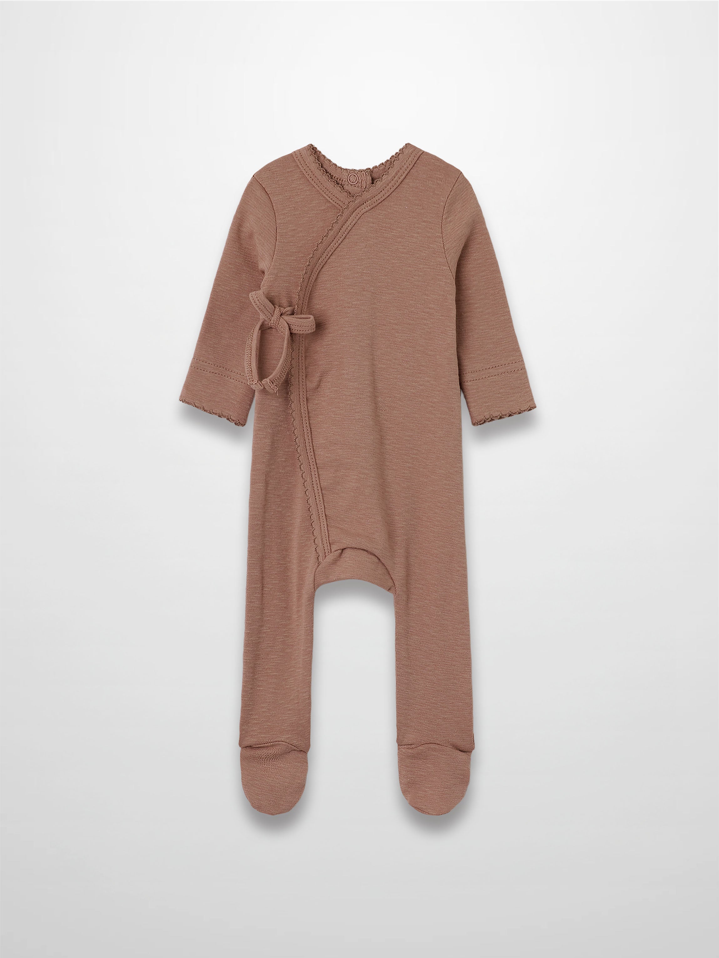 Dusty pink stretchy baby girl jumpsuit footie with side wrap crossover and scalloped trim.