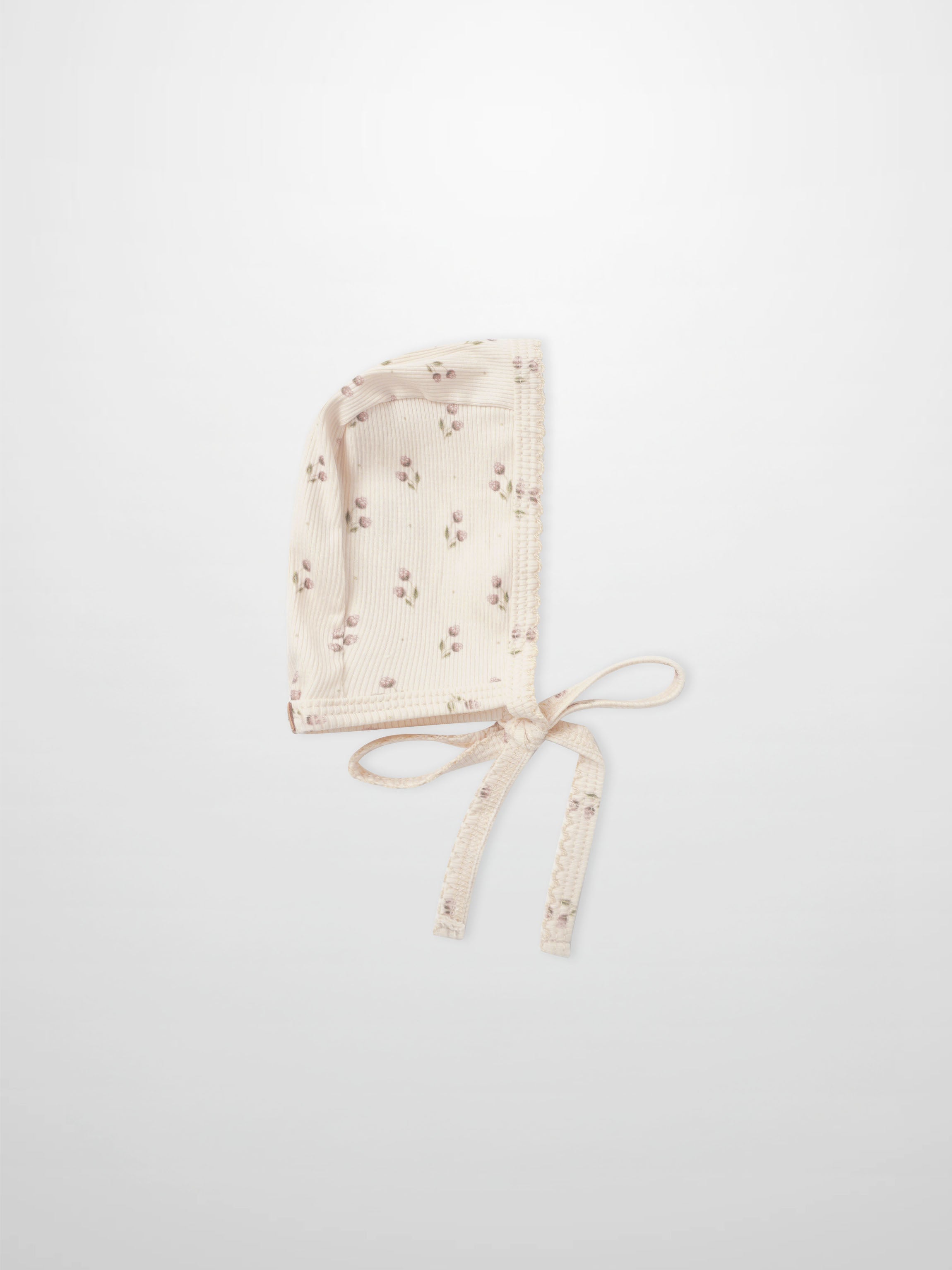 Adee Tiny Tulip layette bonnet in cream ribbed fabric with pink floral print and ties