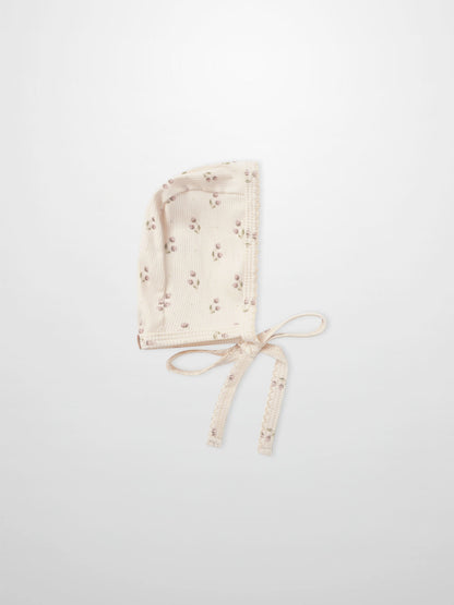 Adee Tiny Tulip layette bonnet in cream ribbed fabric with pink floral print and ties