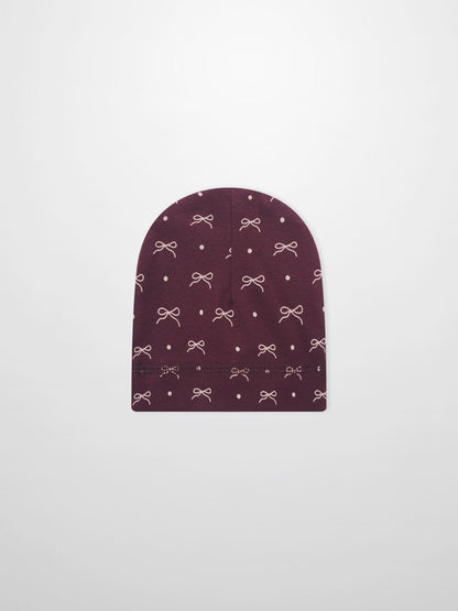 Girls burgundy bow hat with white bow and dot pattern on knit fabric
