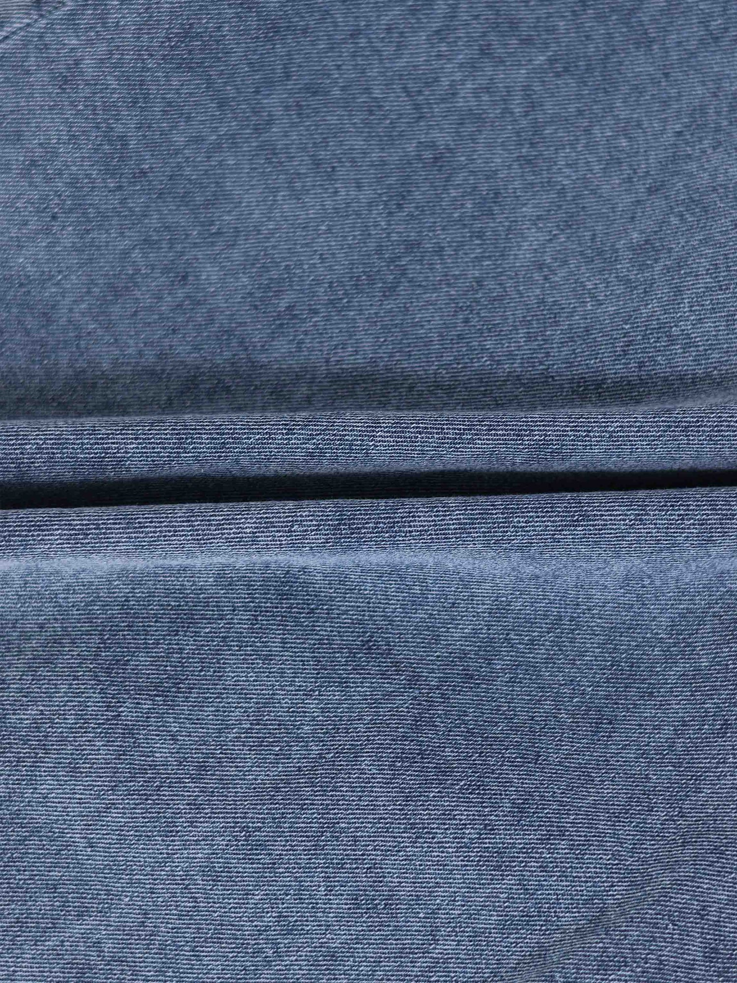 Paneled blue denim skirt fabric close-up.