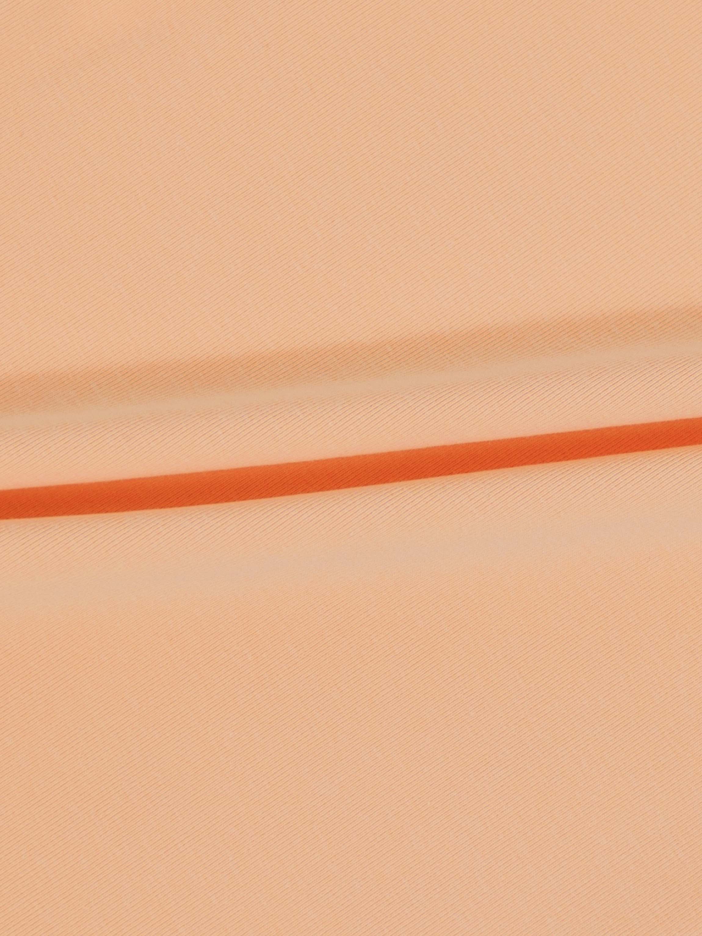 Peach fabric close-up with an orange seam line, for a 6-panel skirt design.
