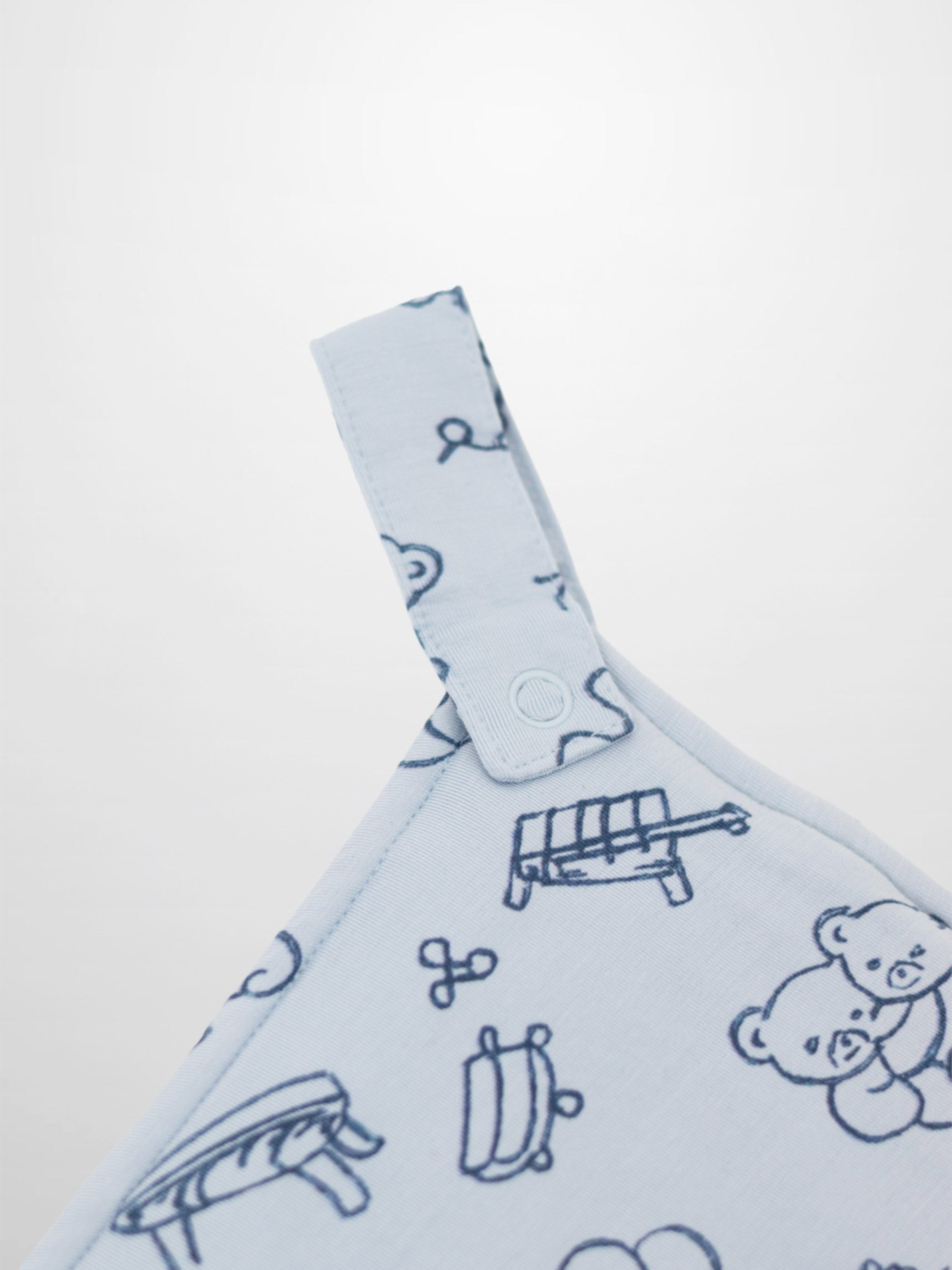 Light blue Storybook Lovey with Clip featuring dark blue carousels, teddy bears, balloons and rocking horses.