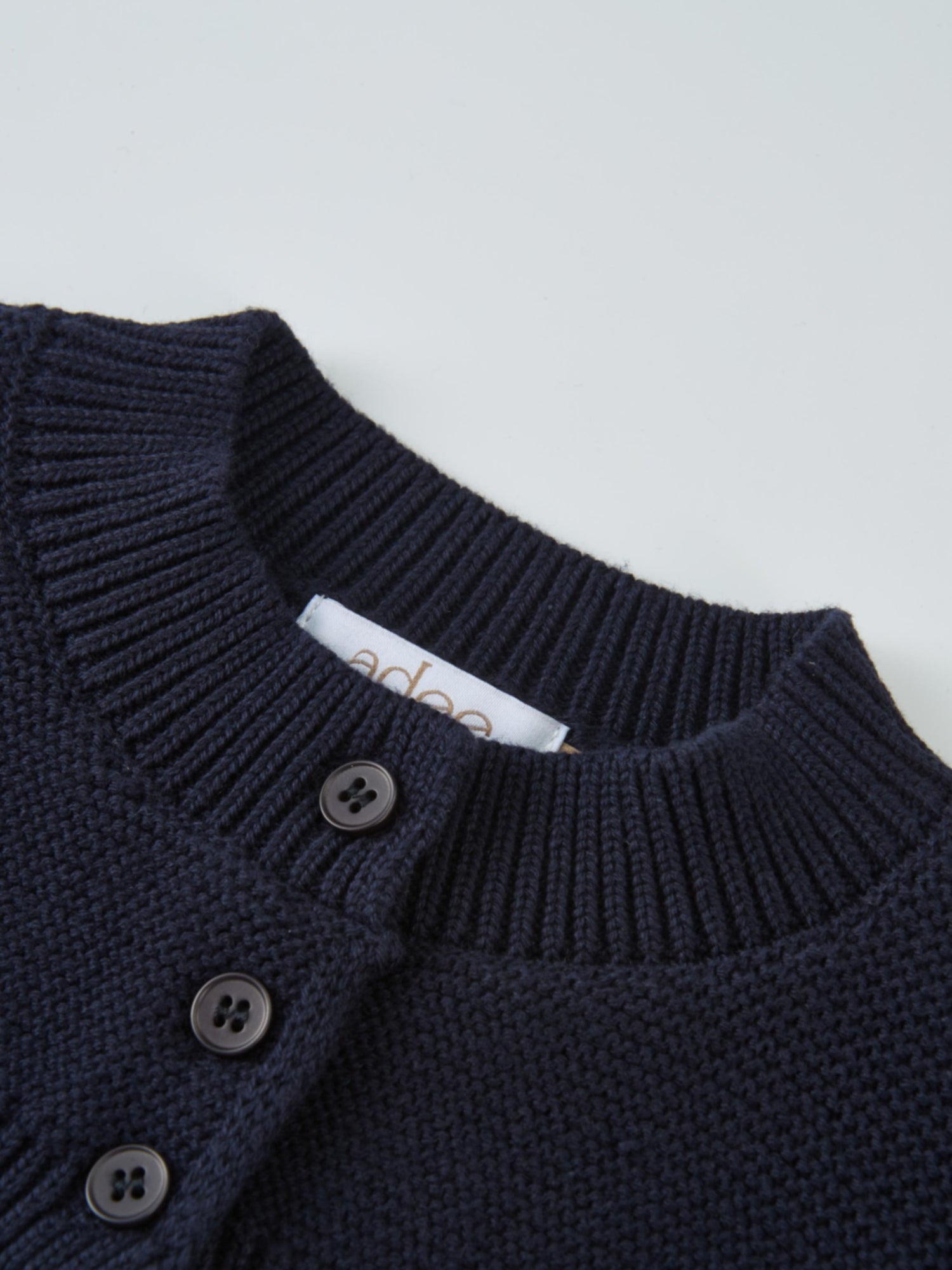 Cropped cardigan in navy by Adee, dressy unisex knit with button-front detail.