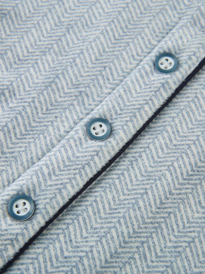Herringbone Pajamas – Blue for boys by Adee; close-up of blue-gray herringbone fabric with blue buttons and navy trim.