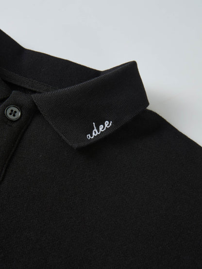 Collared sweatshirt by Adee in black, close-up of the collar with white embroidered brand name.