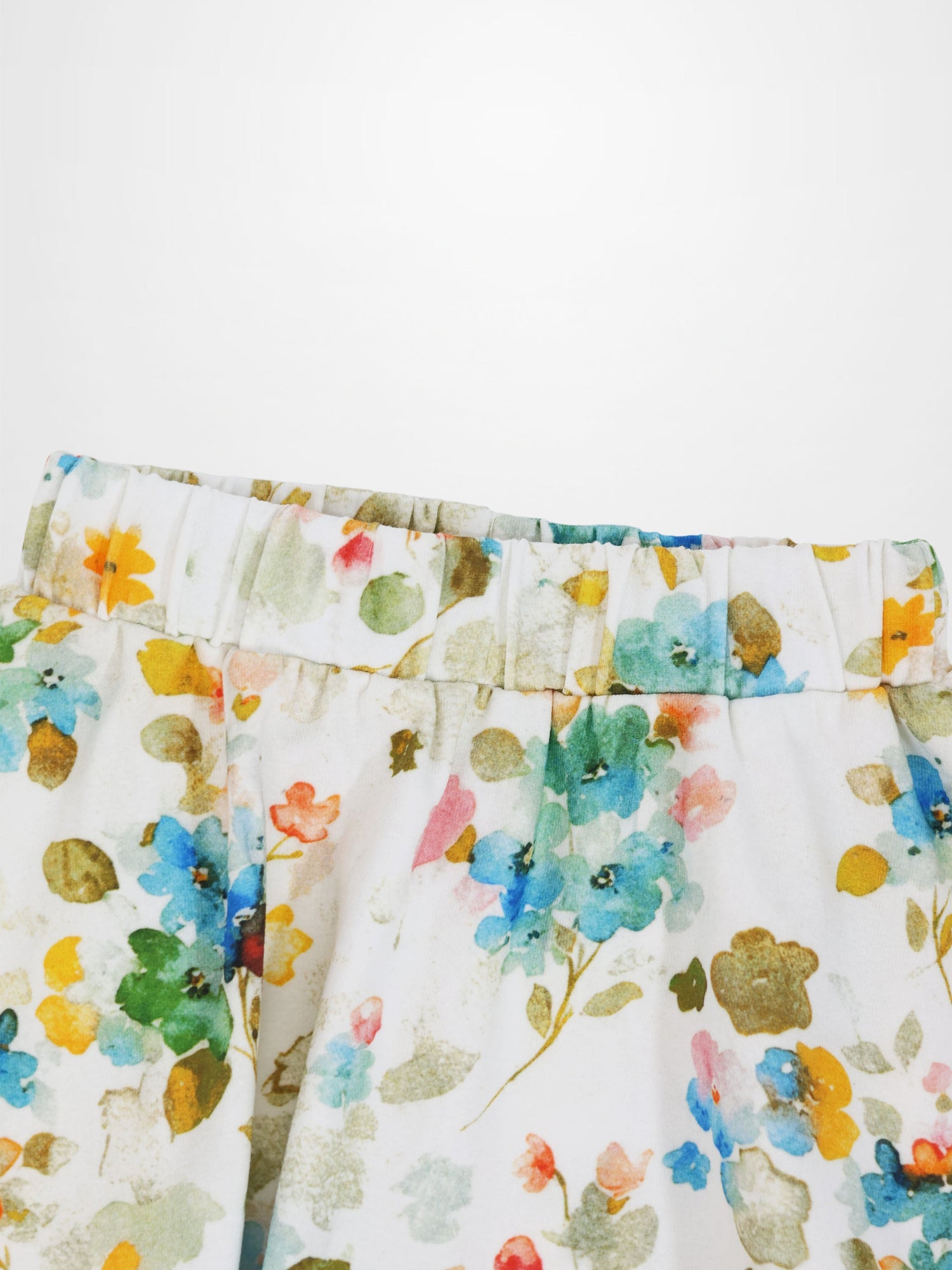 Pastel floral skirt with elastic waistband and watercolor bloom print on white fabric.