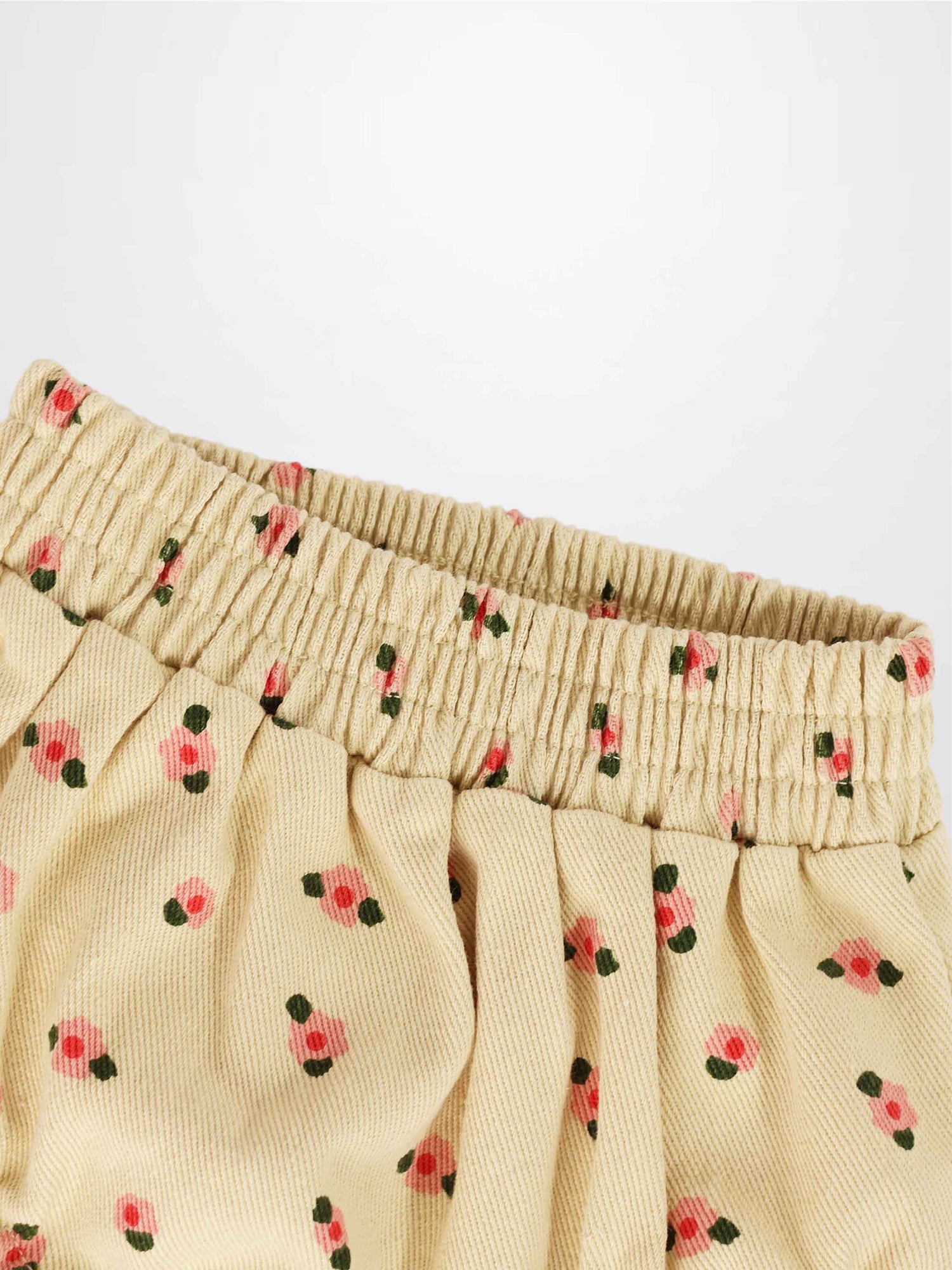 Tan floral bloomers for girls with an elastic shirred waistband and pink flower print fabric.