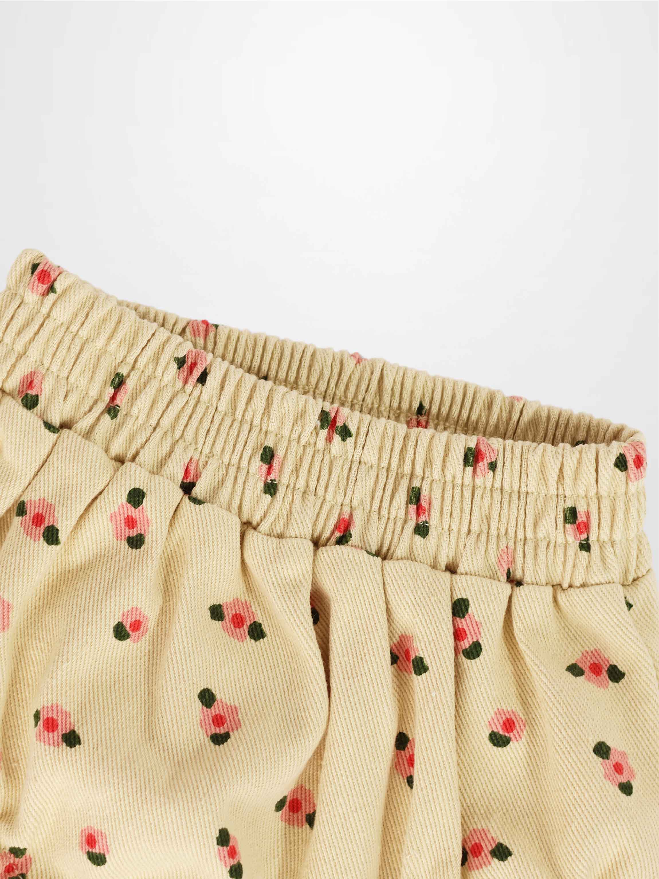 Tan floral bloomers for girls with an elastic shirred waistband and pink flower print fabric.