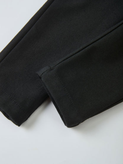Denim overalls by Adee in black, unisex; close-up of fabric and seam.