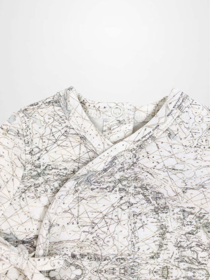 Map Stretchy baby jumpsuit footie with sage-green map lines, compass markers on off-white fabric.