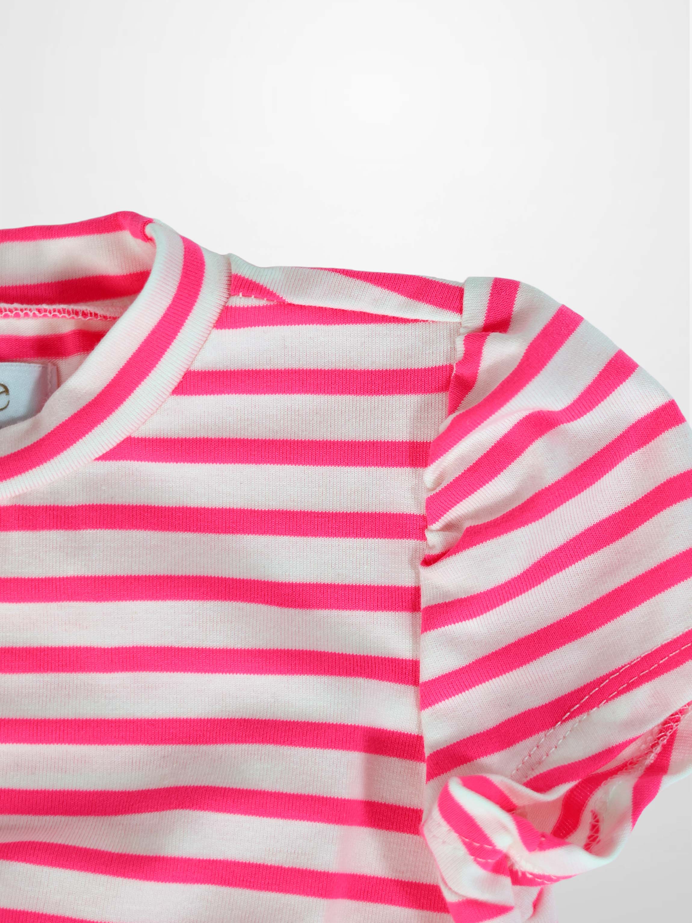 Close-up of neon pink and white striped knit dress with short sleeves and ribbed neckline.