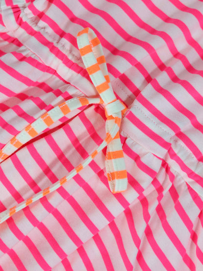 Neon pink striped dress with short sleeves and a white-and-orange striped waist bow.