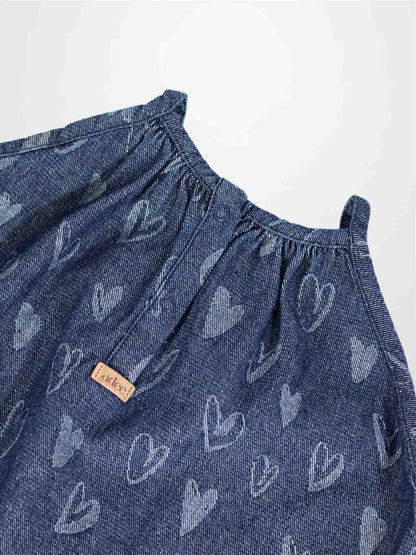 Denim heart jumper with light-gray heart prints, gathered neckline, and snap buttons.