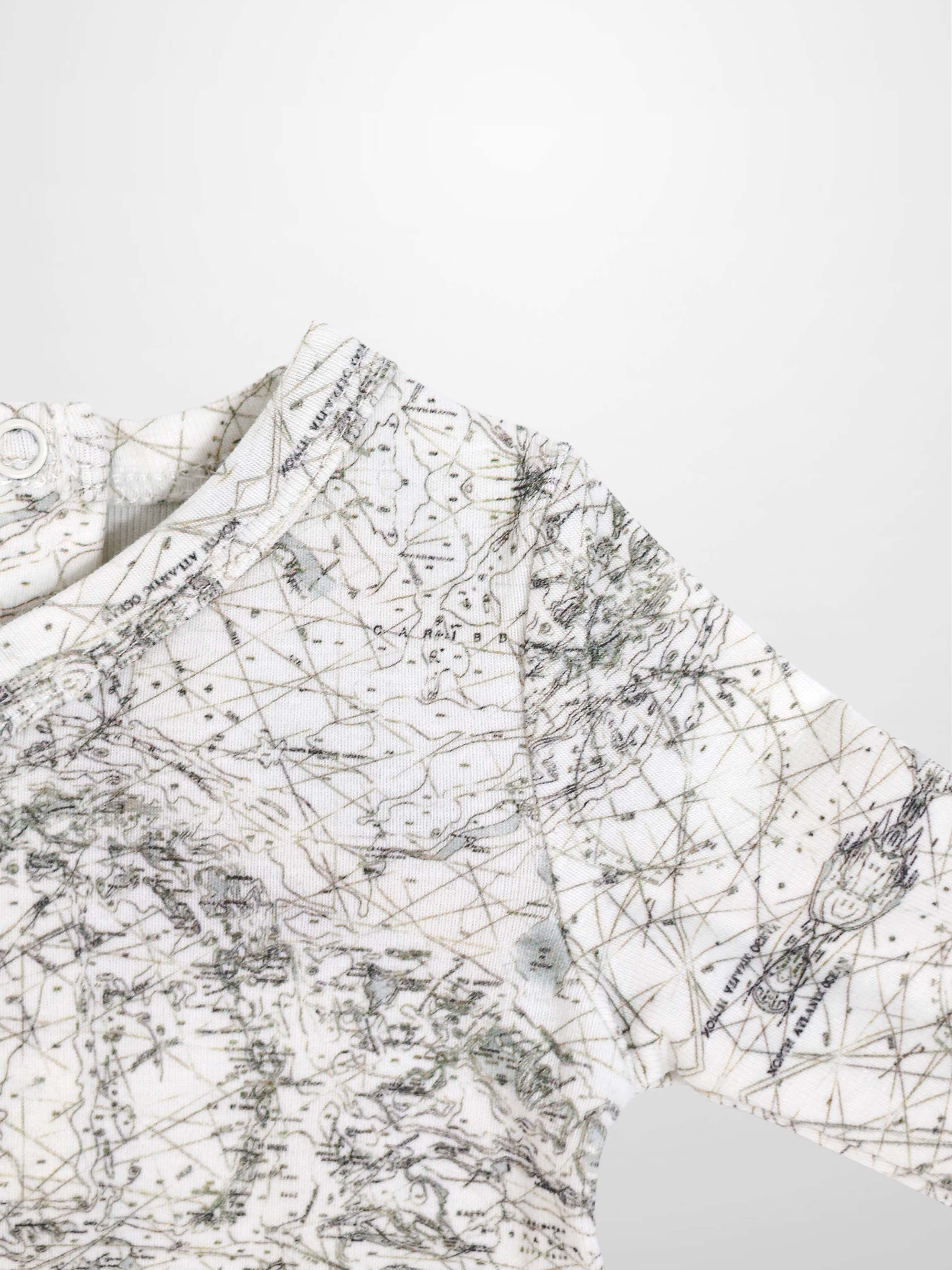 Map Stretchy baby boy jumpsuit footie with off-white fabric and sage-green map lines and compass markers.