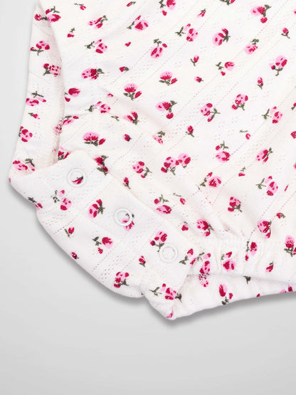 Pointelle Floral Romper for girls in white with pink floral print and snap-button cuffs