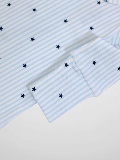 Close-up of light blue and white striped fabric with dark blue stars and scalloped cuff from a Blue Star Stretchy jumpsuit.