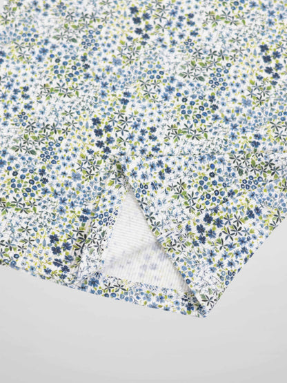 Blue floral pajama fabric with tiny blue and green flowers on white background.