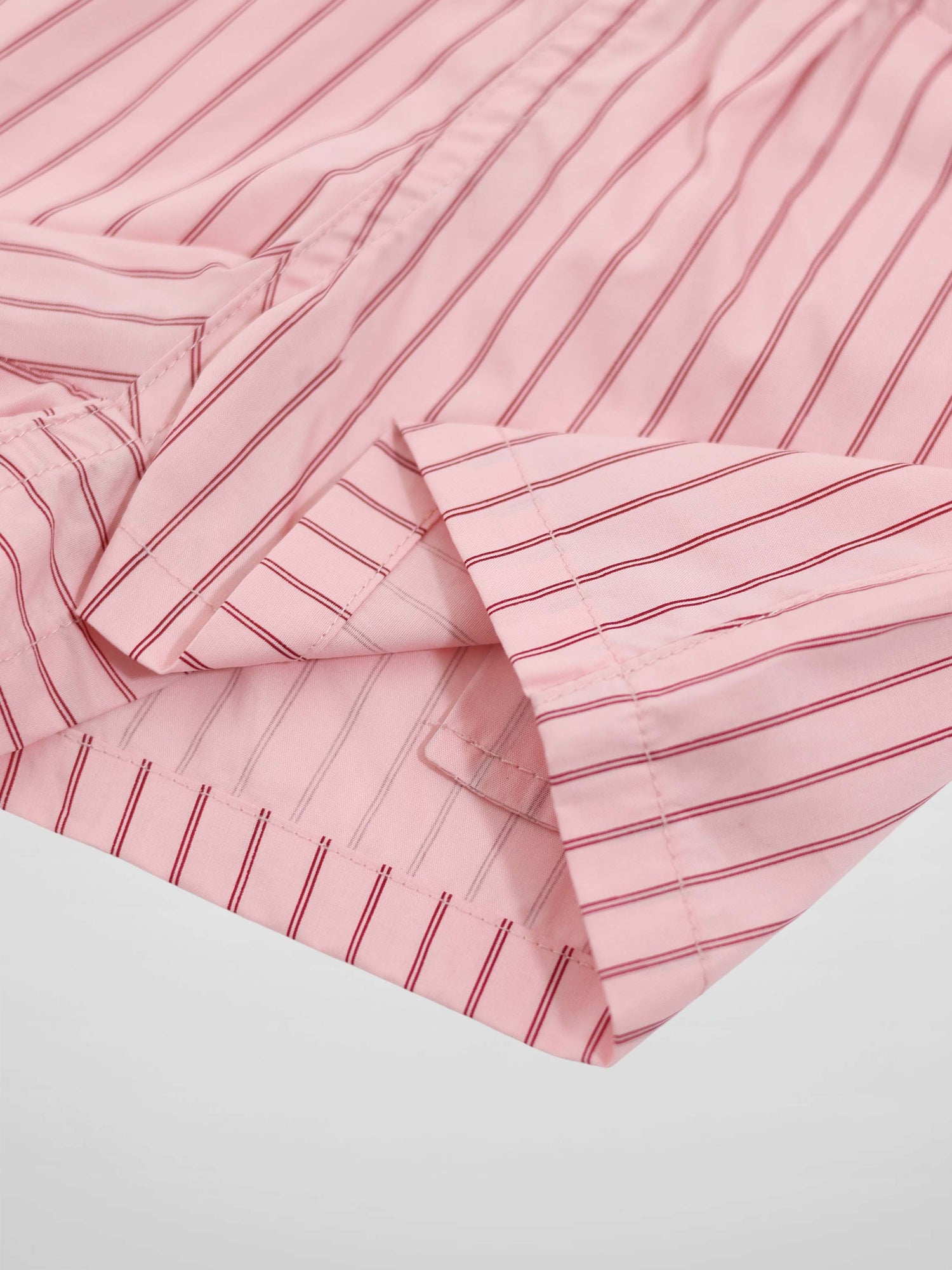 Pink striped cotton shorts with red pinstripes, close-up hem detail