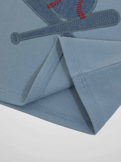 Blue baseball T-shirt with embroidered baseball and bat motif, close-up seam detail.