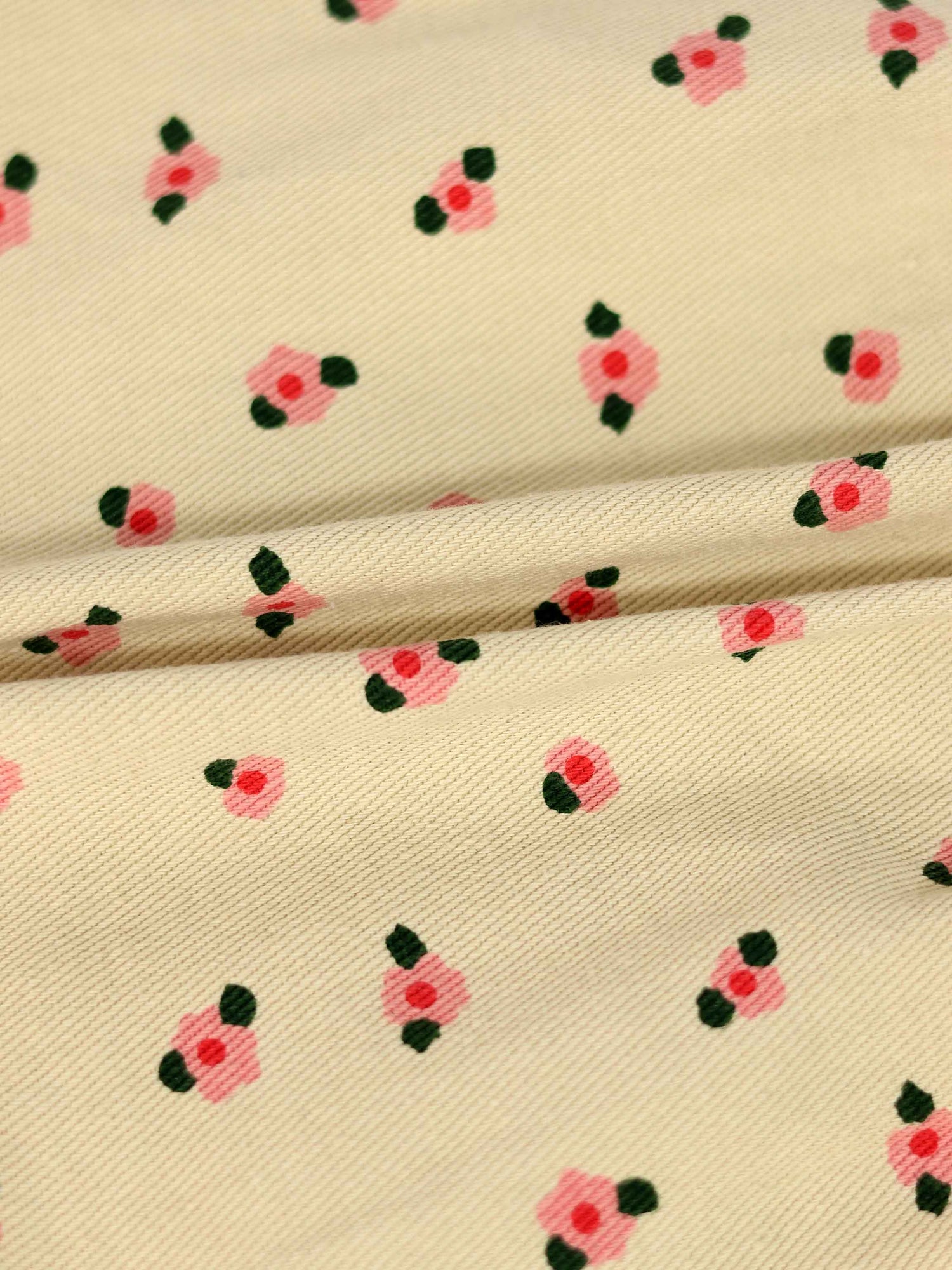 Tan fabric with small pink flowers and green leaves pattern, suitable for a floral skirt