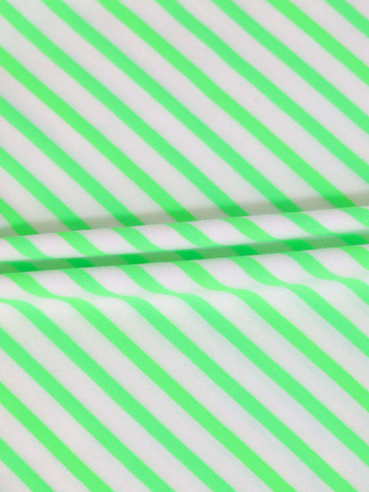 Close-up of neon green diagonal striped fabric for a romper.