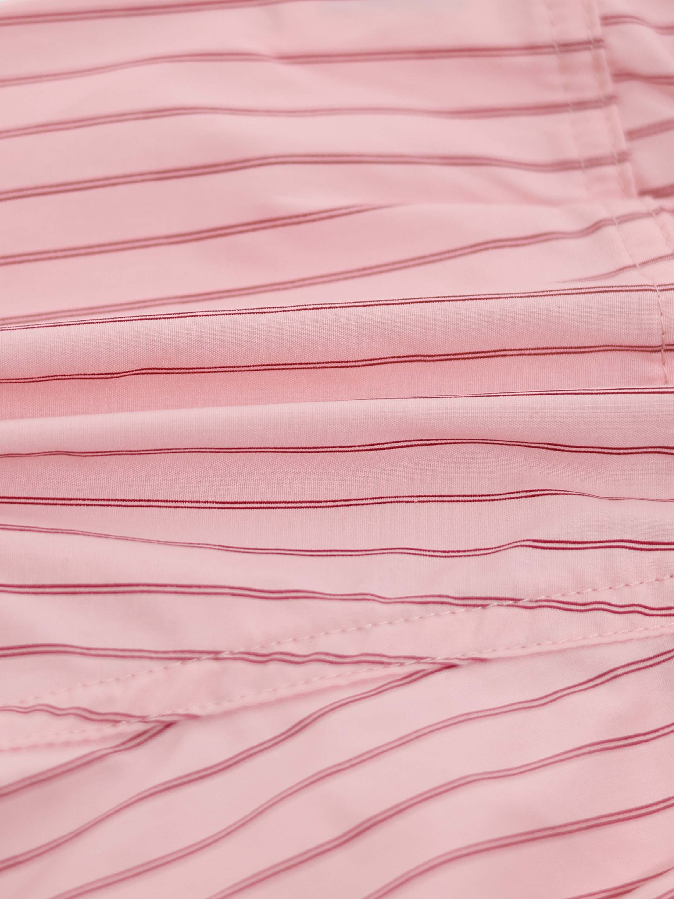 Close-up of pink striped cotton shorts fabric with visible stitching.