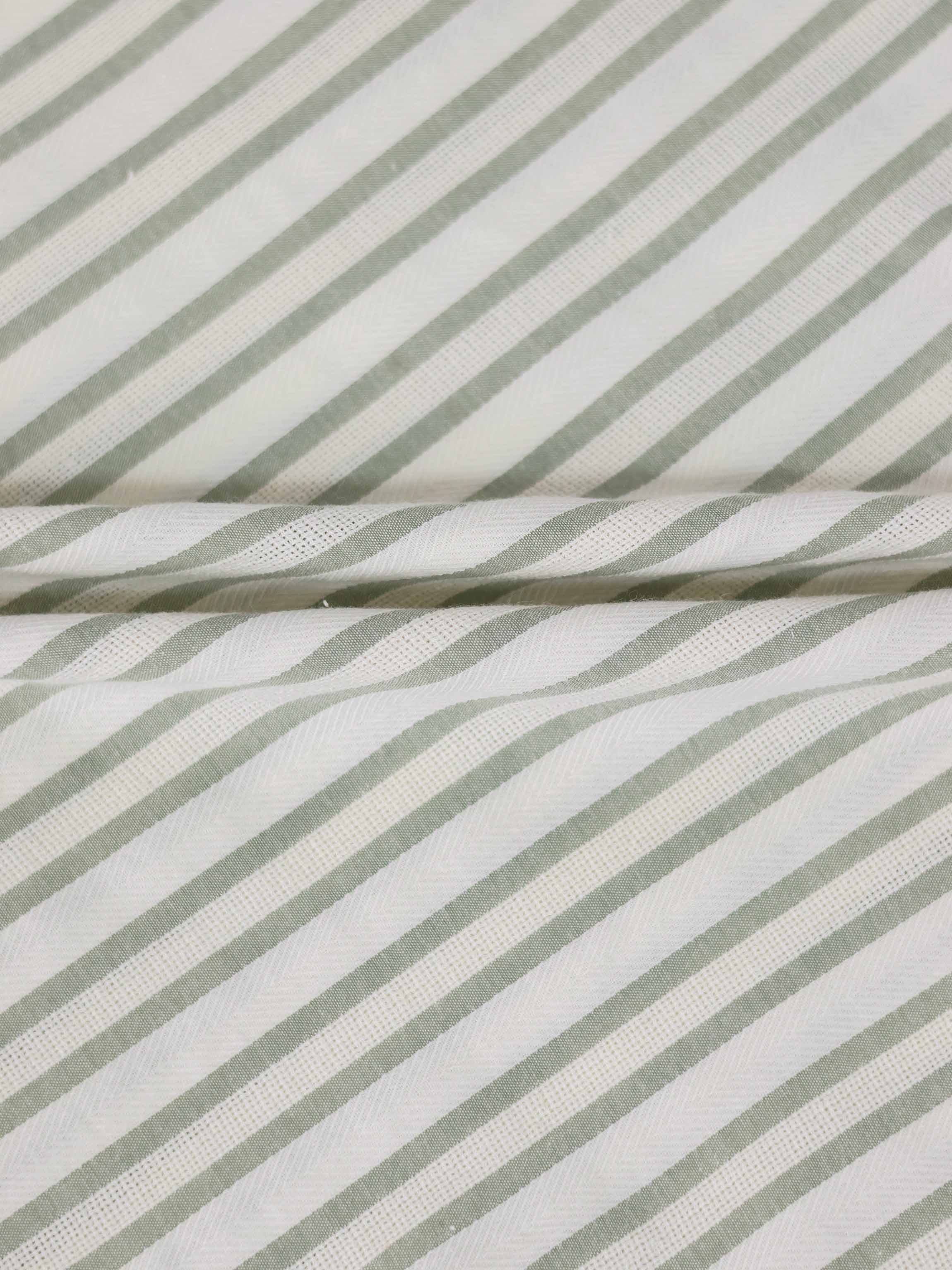 Green striped dress fabric close-up with white and sage diagonal stripes.