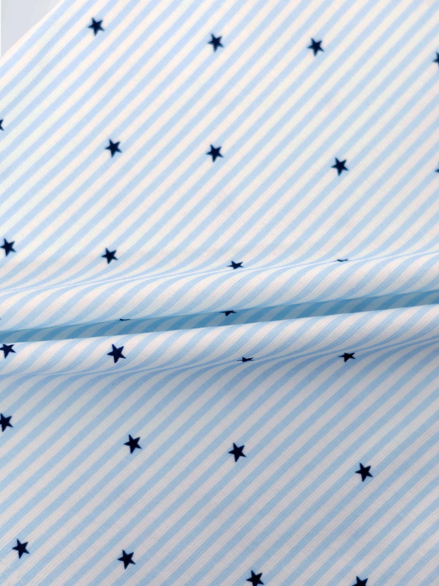 Blue Star Stretchy: light blue and white striped baby jumpsuit footie with navy stars.