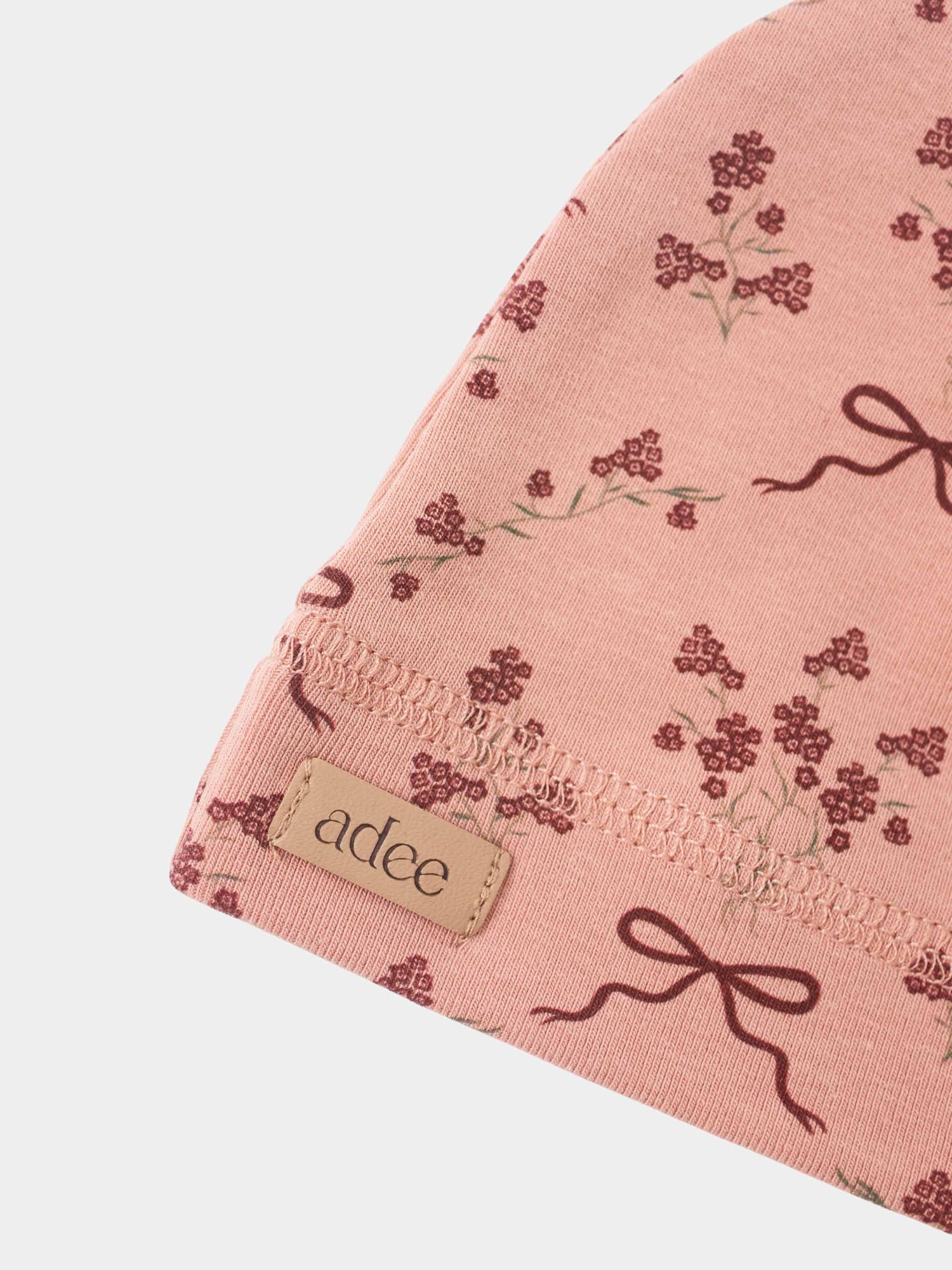 Adee Bow Bouquet Layette Set for girls; pink fabric with burgundy floral print and bow motif.