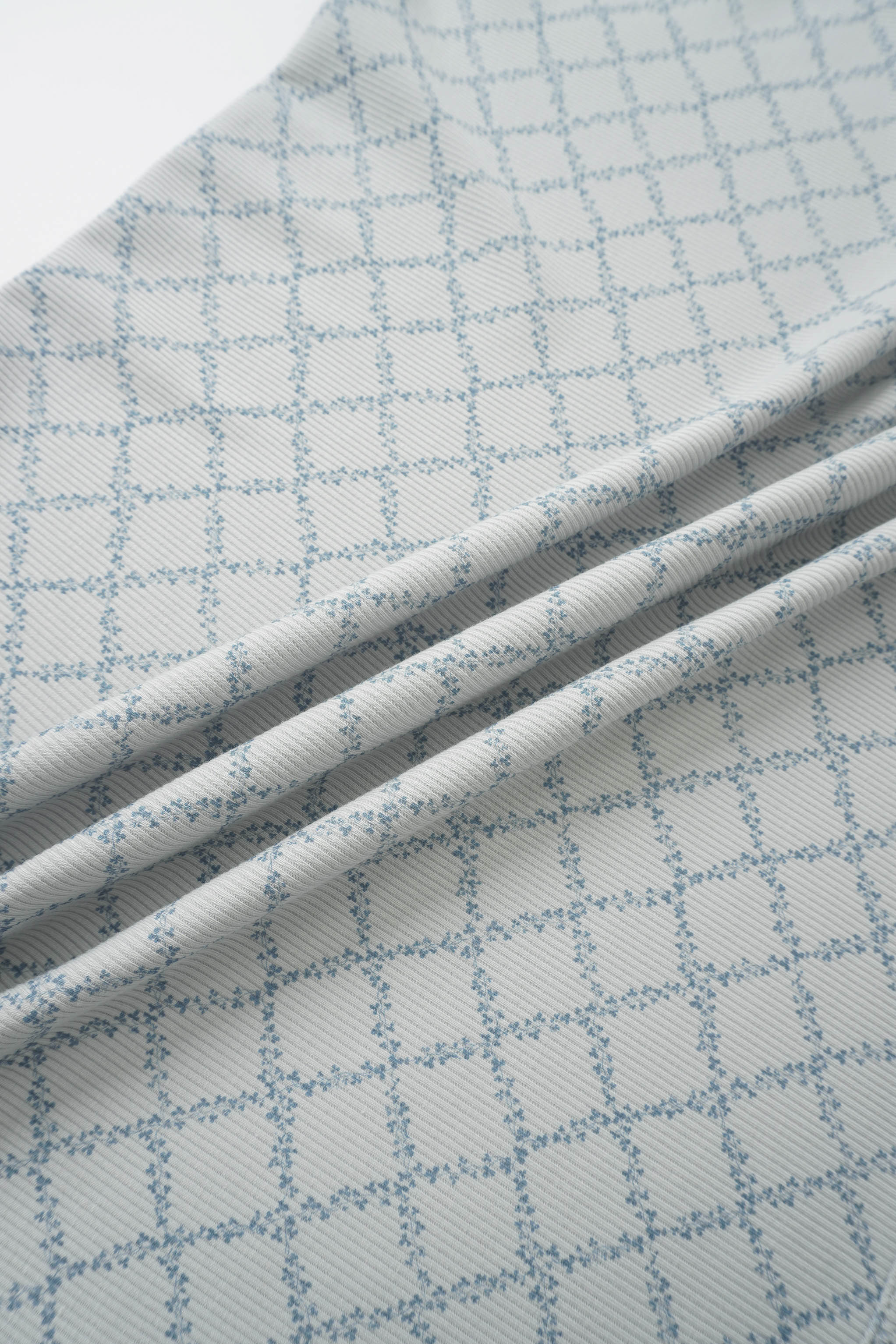 Blue Leaf Layette Set fabric with white base and light blue grid pattern