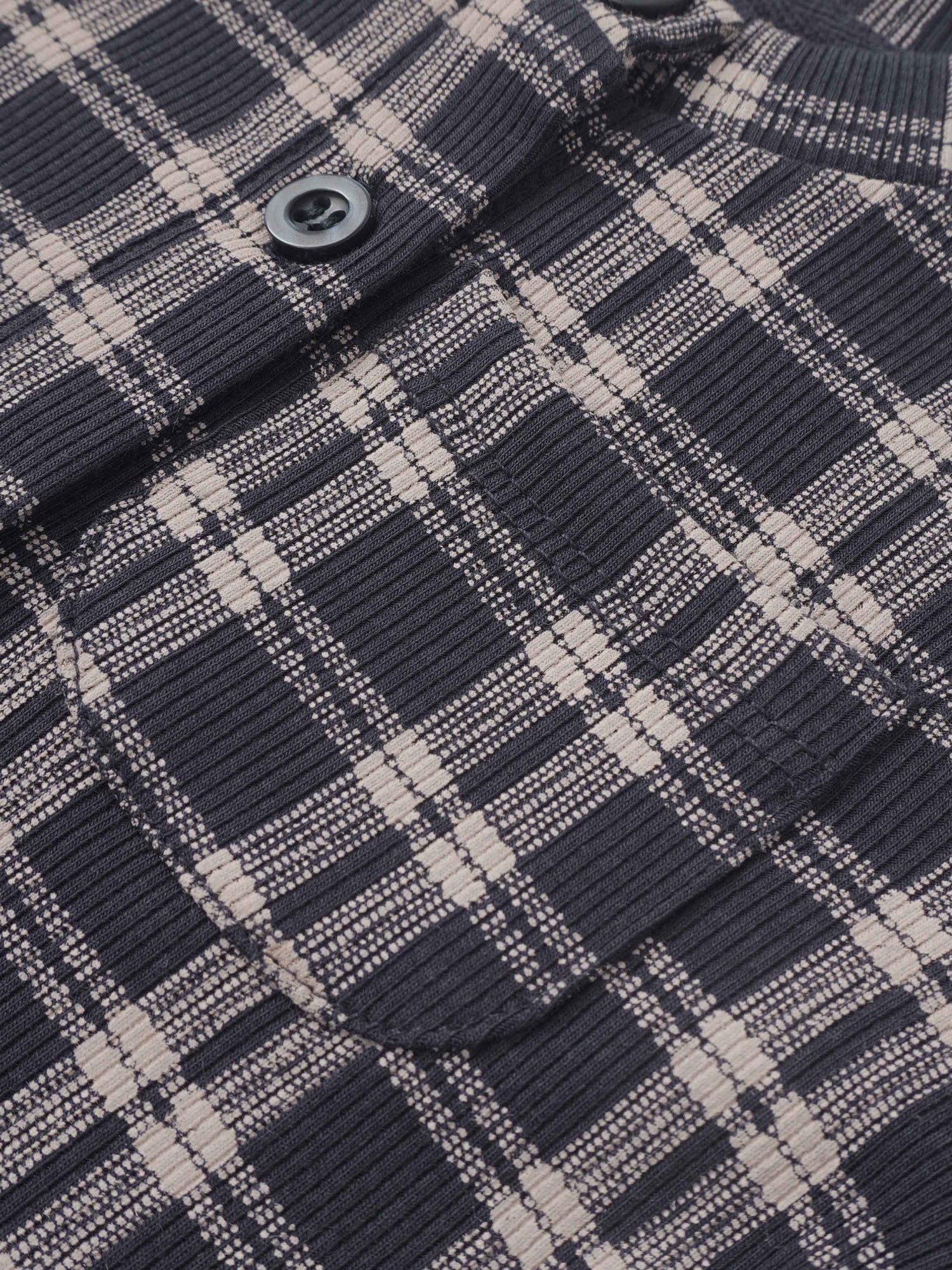 Plaid blue boys pajamas fabric close-up with a visible button