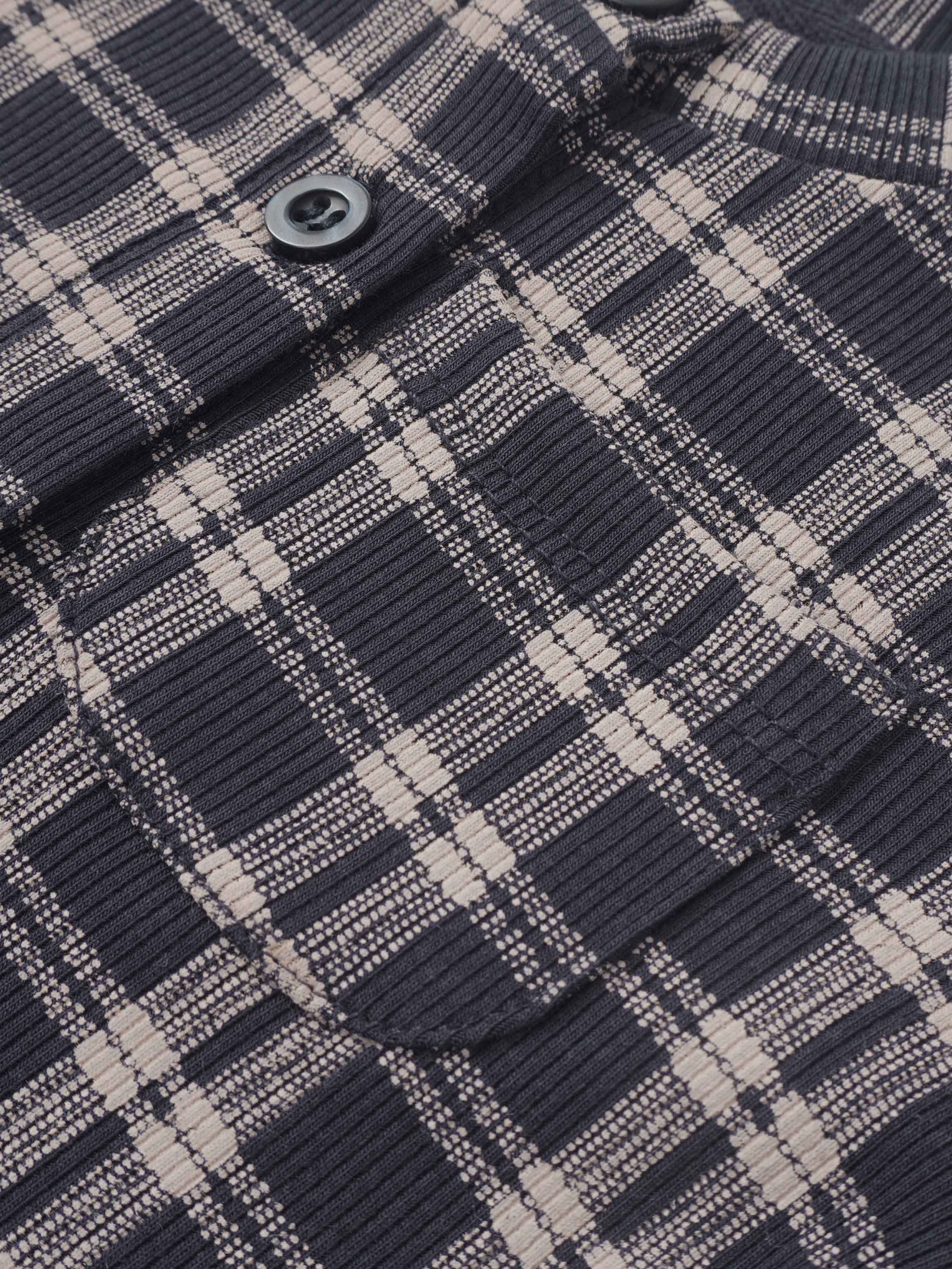 Plaid blue boys pajamas fabric close-up with a visible button