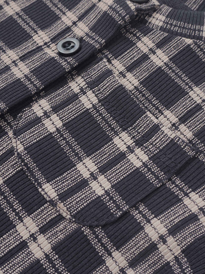 Plaid blue boys pajamas fabric close-up with a visible button