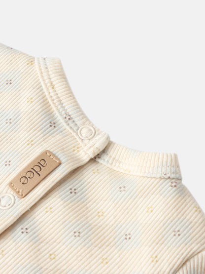 Little Button Blue layette set by Adee; cream ribbed cotton fabric with tiny embroidered specks and white button.