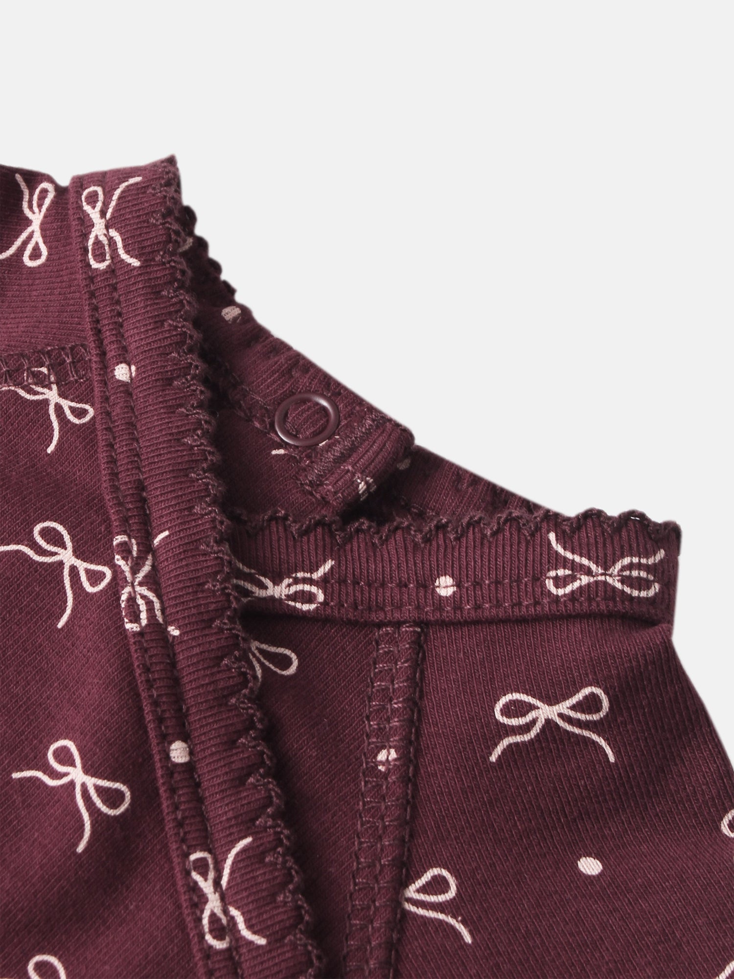 Burgundy bow layette set for girls, ribbed fabric with white bow pattern and button detail.