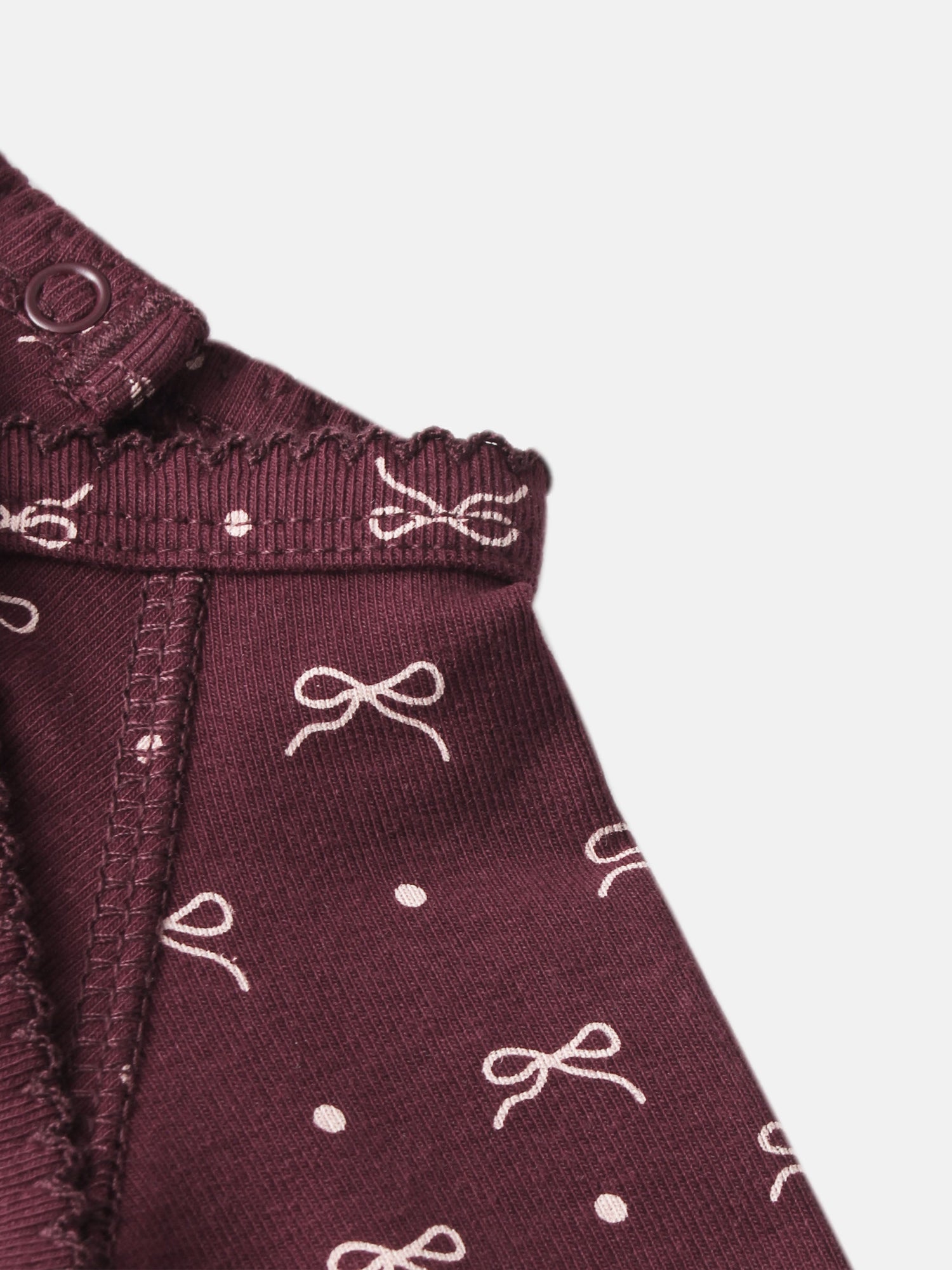 Burgundy Bow layette set by Adee; knit fabric with white bow pattern and front button.