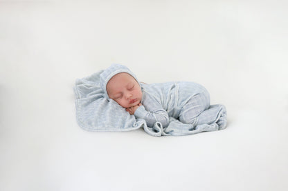 Heritage Herringbone Blue layette set, baby swaddled in blue herringbone fabric.
