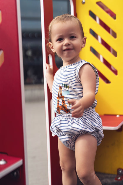 Toddler wearing Eiffel Tower bloomers and striped tank set at playground.