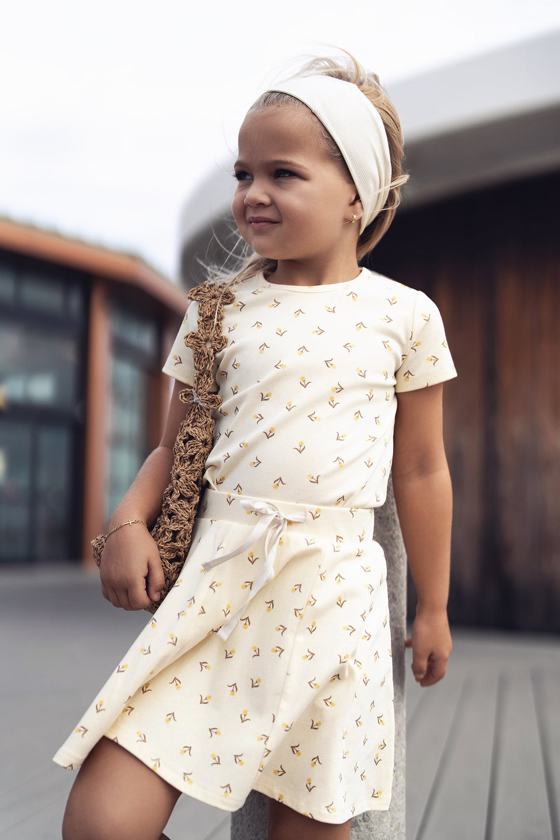 Butter Yellow Tulip Short Sleeve T-shirt with floral prints worn by a young girl with a cream headband.